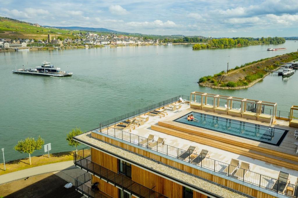 ein großer Fluss mit einem Boot im Wasser in der Unterkunft PAPA RHEIN - Hotel & Spa in Bingen am Rhein