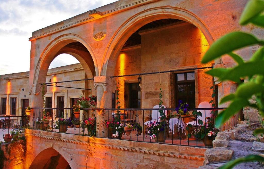 a building with a balcony with flowers on it at Assiana Cave Hotel in Ürgüp