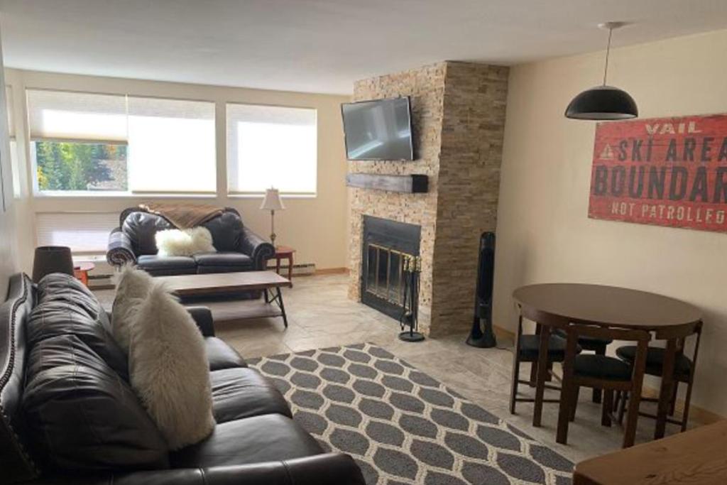 a living room with a leather couch and a fireplace at Pitkin Creek Park 7 in Vail