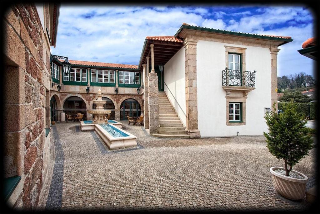 a building with a swimming pool in front of it at Hotel Fonte da Vila in Monção