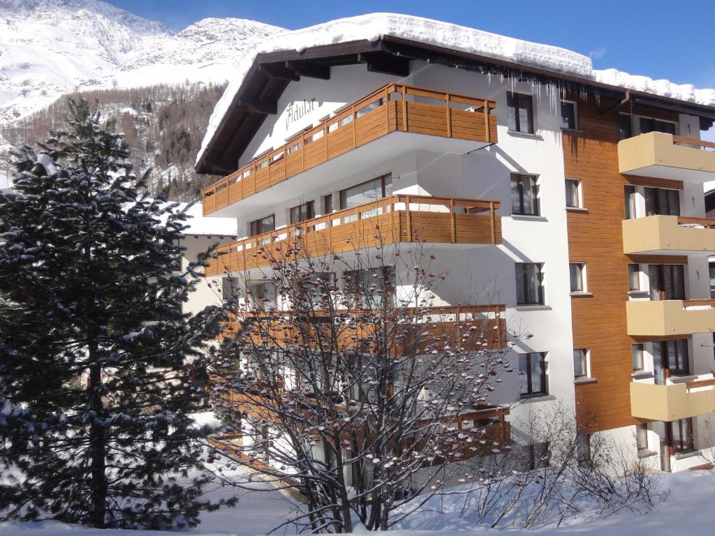 a building with a balcony in the snow at Adular in Saas-Fee