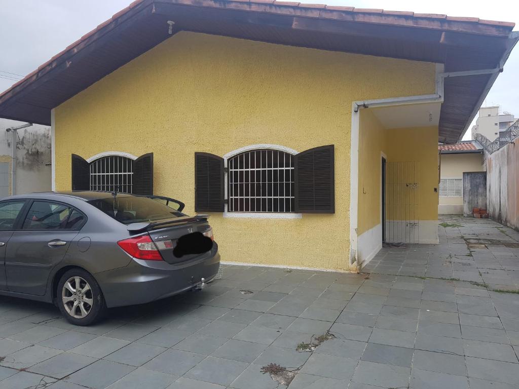 ein vor einem gelben Gebäude geparkt in der Unterkunft Casa de Temporada Próximo a Praia in Caraguatatuba