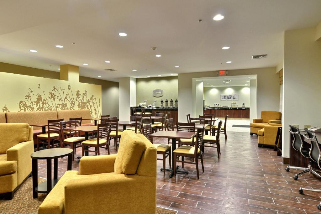 a restaurant with tables and chairs and a bar at Sleep Inn & Suites Parkersburg in Parkersburg