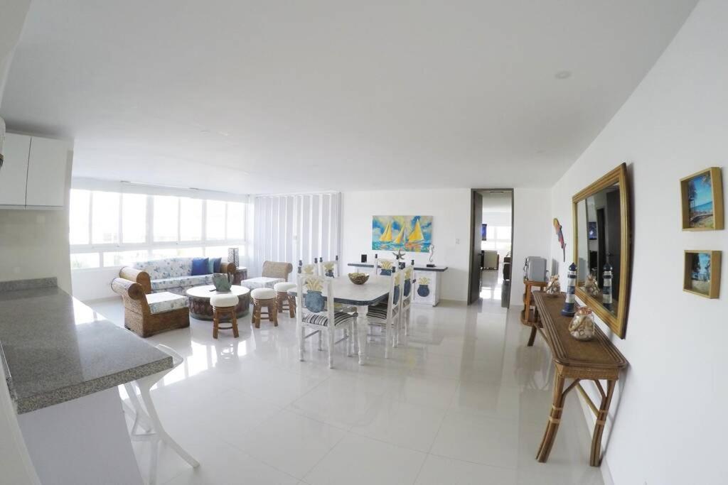 Hermoso y amplio apartamento con vista al mar في سان أندريس: غرفة معيشة بيضاء مع طاولة وكراسي