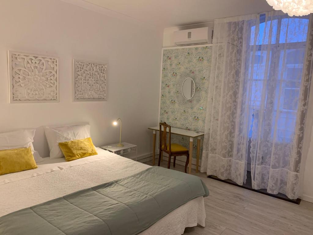 
a bedroom with a large bed and a large window at Formosa Guest House in Tavira
