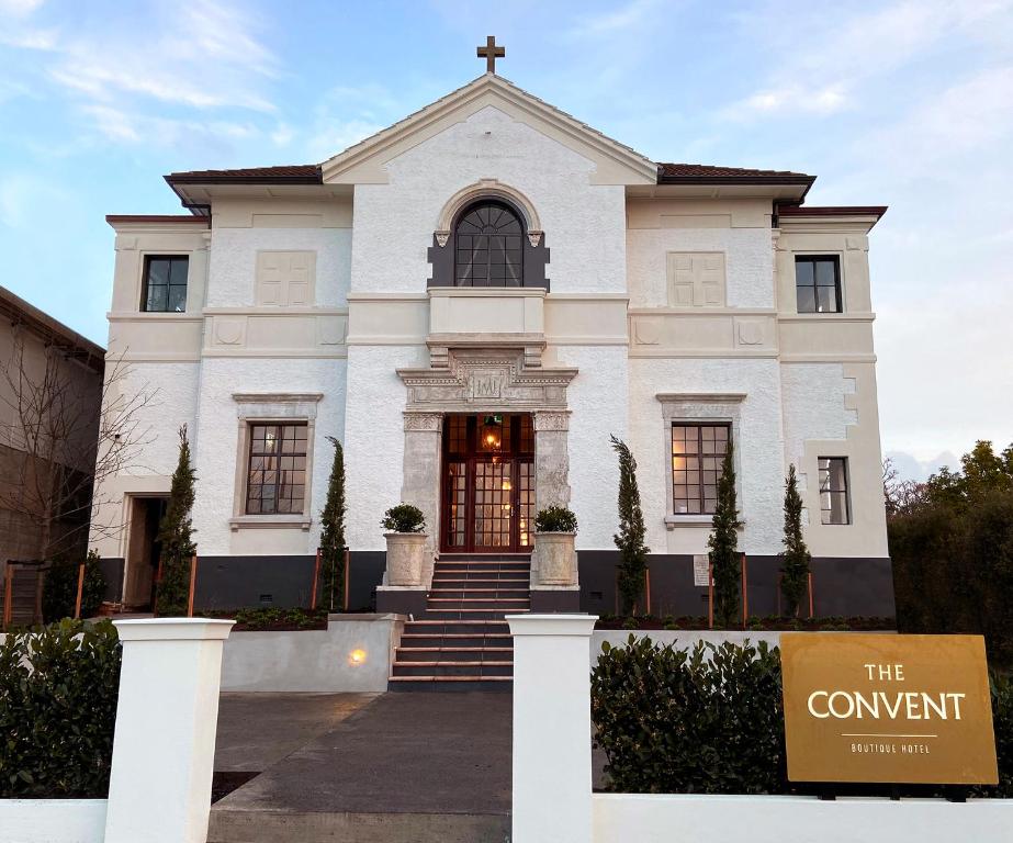 uma igreja branca com um sinal em frente em The Convent Hotel em Auckland