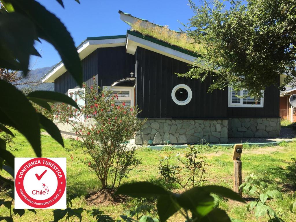 ein Haus mit einem Schild davor in der Unterkunft Cabañas Chaya Mapu in Puerto Aisén