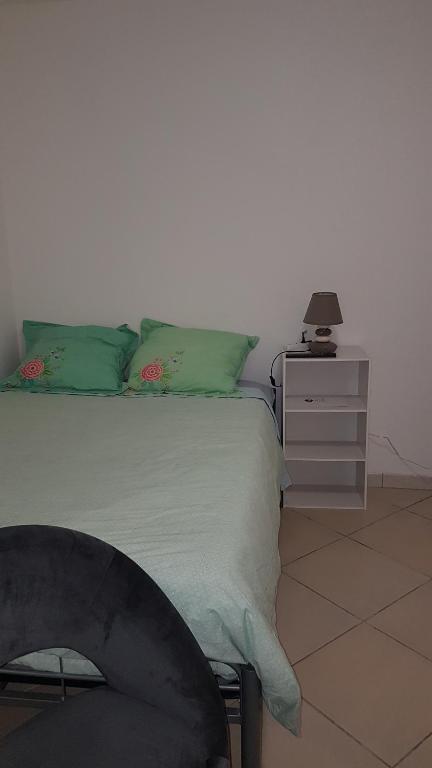 ein Schlafzimmer mit einem Bett und einem Nachttisch mit einer Lampe in der Unterkunft MAGNIFIQUE STUDIO in Saint-Just-Sauvage