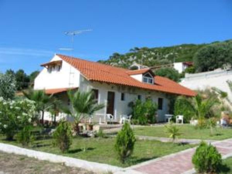 una casa blanca con techo naranja en Summer Garden Αpartments & Studios en Argostoli