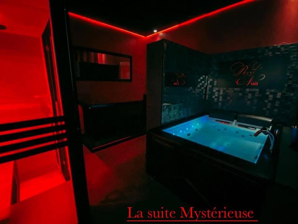 La salle de bains est pourvue d'une baignoire dans les tons rouges. dans l'établissement Le rêve d’une nuit suite mystérieuse, à Sarreguemines