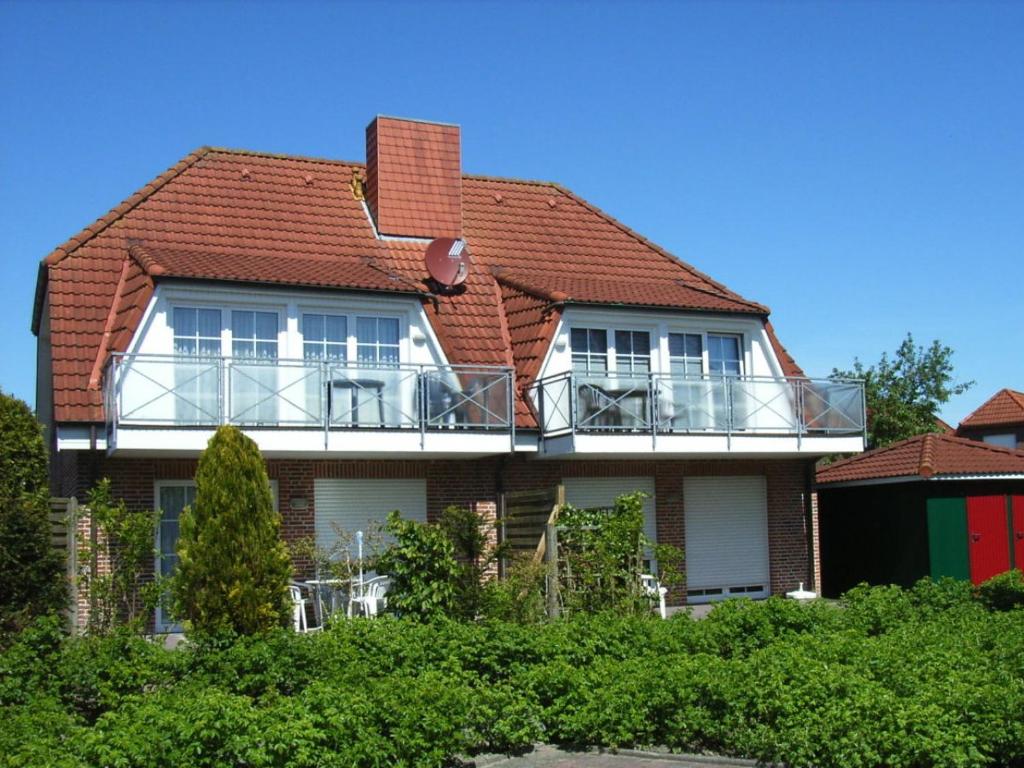 a house with a balcony on top of it at Nordseeperle in Wangerland