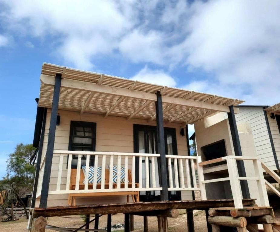 a small house with a porch on a wooden deck at Ocean Paradise 2 in Punta Del Diablo