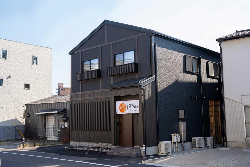 un edificio negro con un cartel en el costado en 瀬戸風月, en Takamatsu