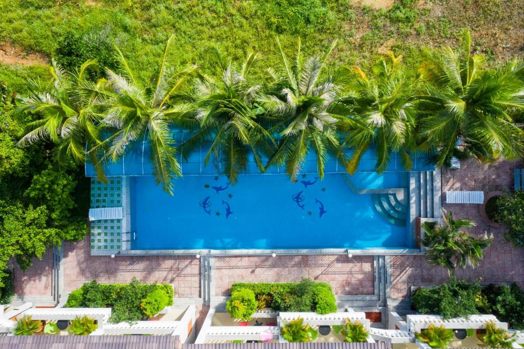 an overhead view of a swimming pool with palm trees at Quynh Mai Resort in Phu Quoc