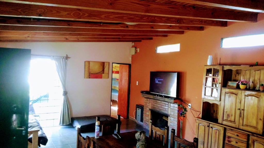 een woonkamer met een televisie en een open haard bij La Bohemia in Las Compuertas