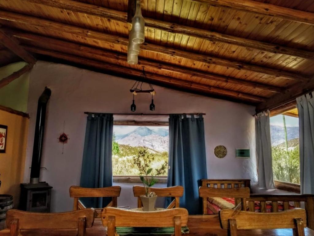 comedor con mesa, sillas y ventana en Valle del Cielo en Uspallata