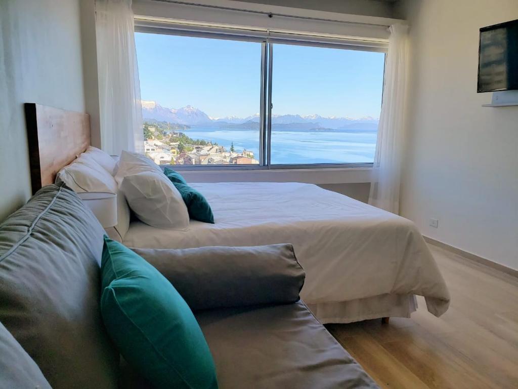 a bedroom with a large bed and a large window at CONDOR STUDIO BARILOCHE in San Carlos de Bariloche