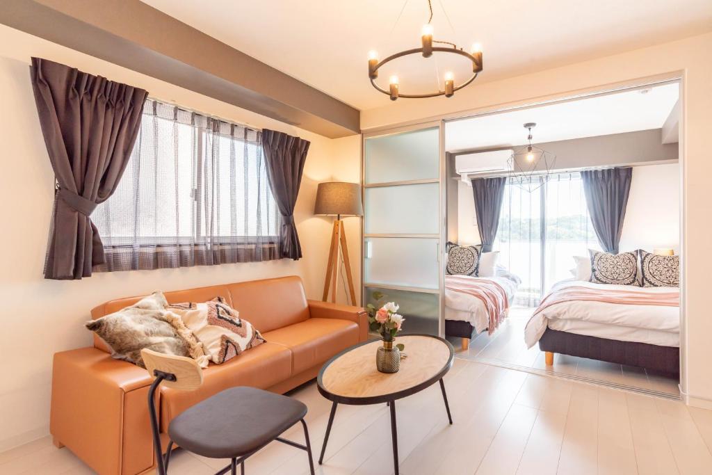 a living room with a couch and a bed at Bijou Suites Bloom in Osaka