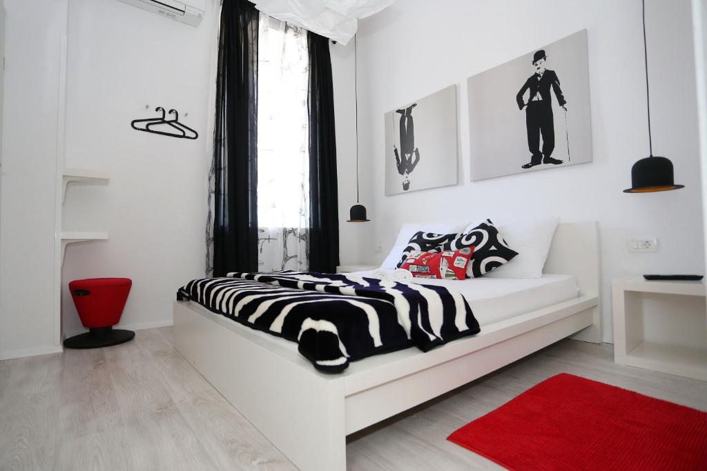 a white bedroom with a black and white bed at The Hostel in Zadar