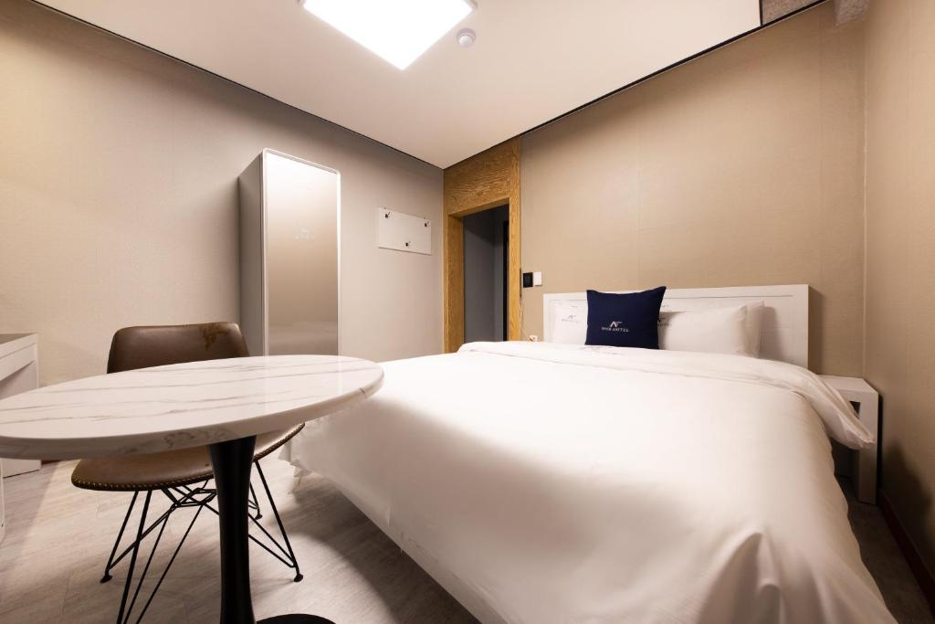a bedroom with a large bed and a table at Cheonan A One Hotel in Cheonan