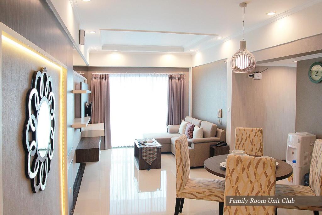 a living room with a couch and a table and chairs at Apartemen Puncak Marina in Surabaya