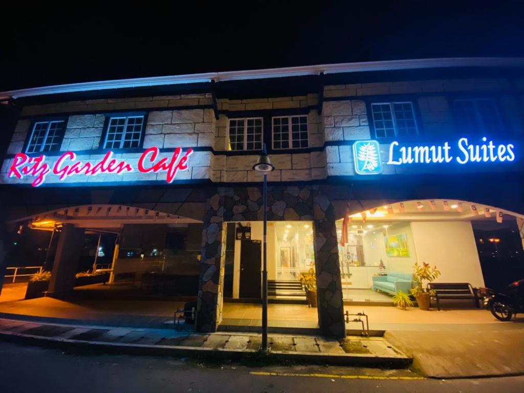 盧穆特的住宿－Lumut Suites，建筑的侧面有 ⁇ 虹灯标志