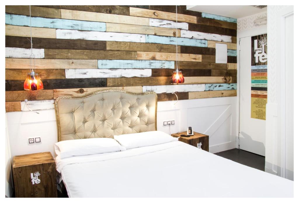 a bedroom with a bed and a wooden wall at Hotel Life Gran Via Design in Madrid