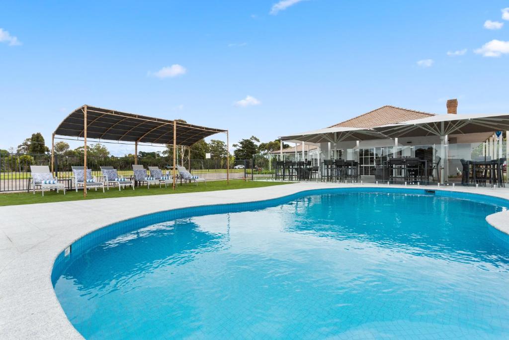 a large blue swimming pool in front of a house at Sanctuary Inn on Westernport in Hastings