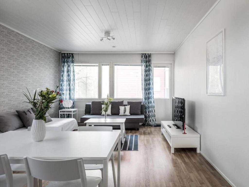 uma sala de estar com um sofá e uma mesa em Kotimaailma Apartments Joensuu em Joensuu