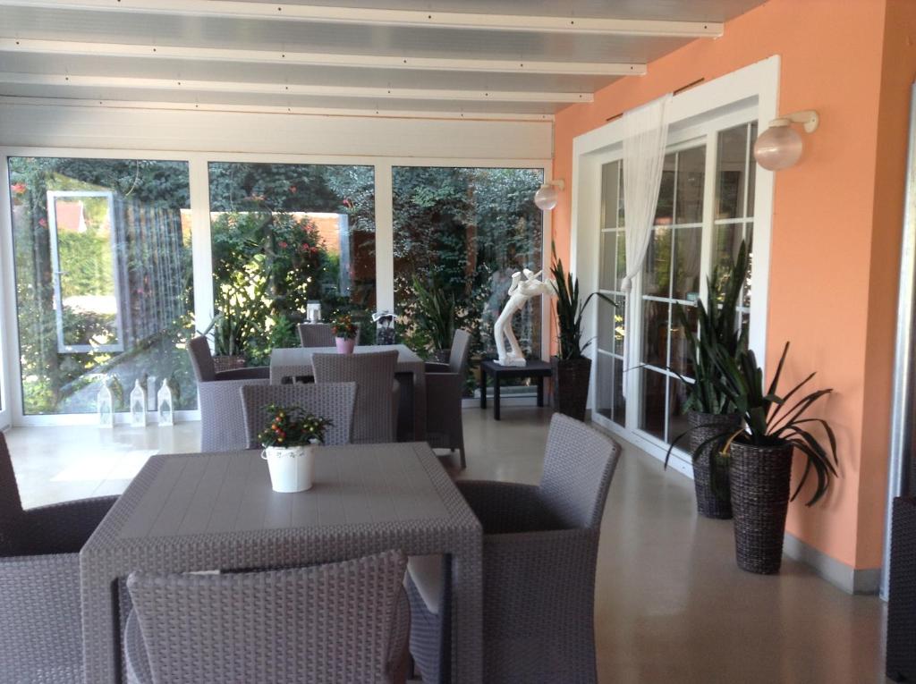 an empty restaurant with tables and chairs and plants at Hotel Zsida in Szentgotthárd