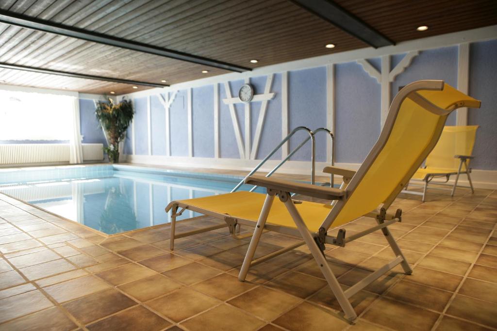 une chaise jaune assise à côté de la piscine dans l'établissement Hotel Krone, à Hirschberg an der Bergstraße