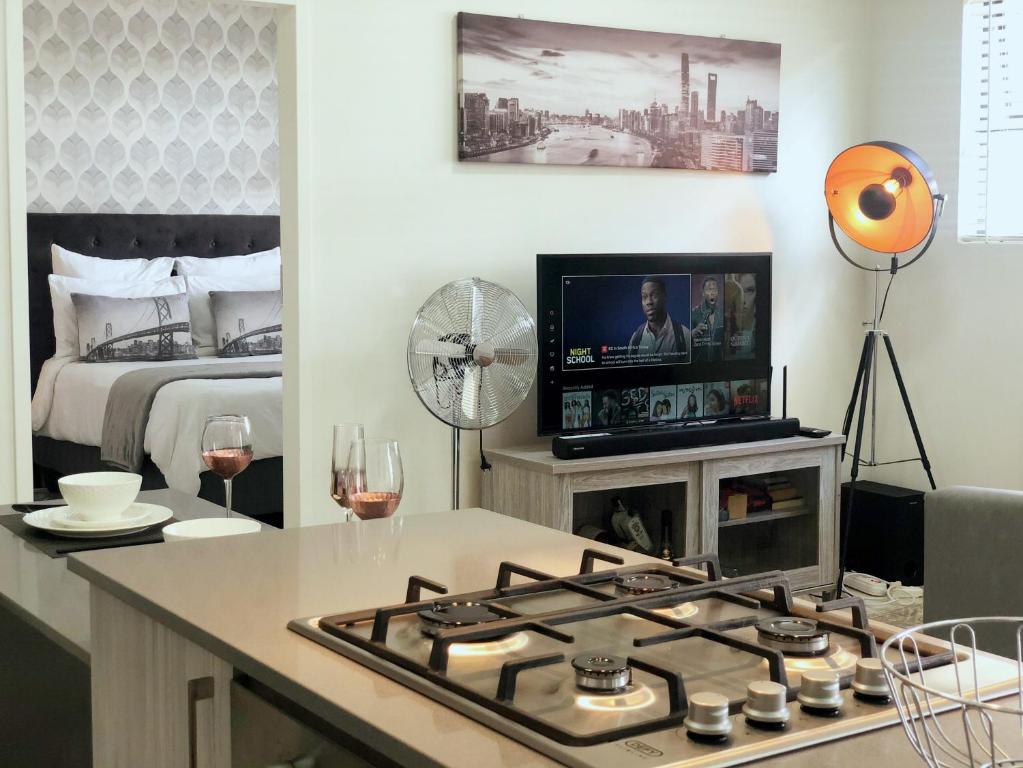 a living room with a stove and a bed at Mikey's place with Fibre Uncapped WiFi in Midrand