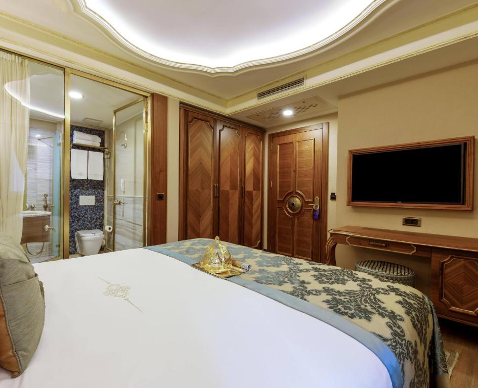 a bedroom with a large bed and a flat screen tv at Romance Istanbul Hotel Boutique Class in Istanbul