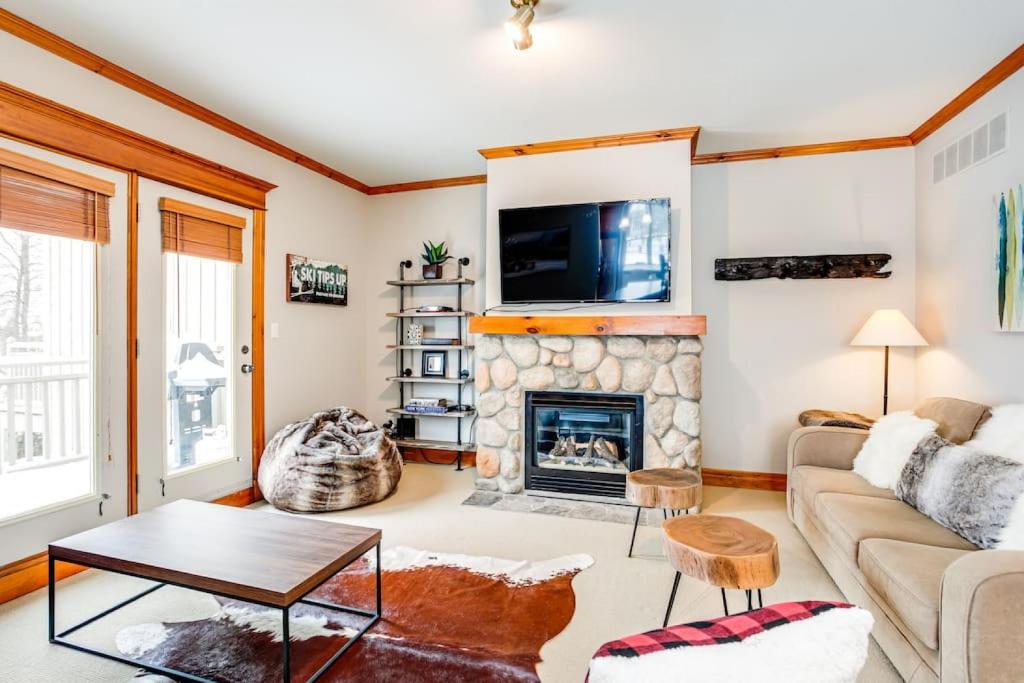 ein Wohnzimmer mit einem Kamin und einem TV in der Unterkunft Blue Mountain 3 bedroom Dream Chalet 81590 in Collingwood