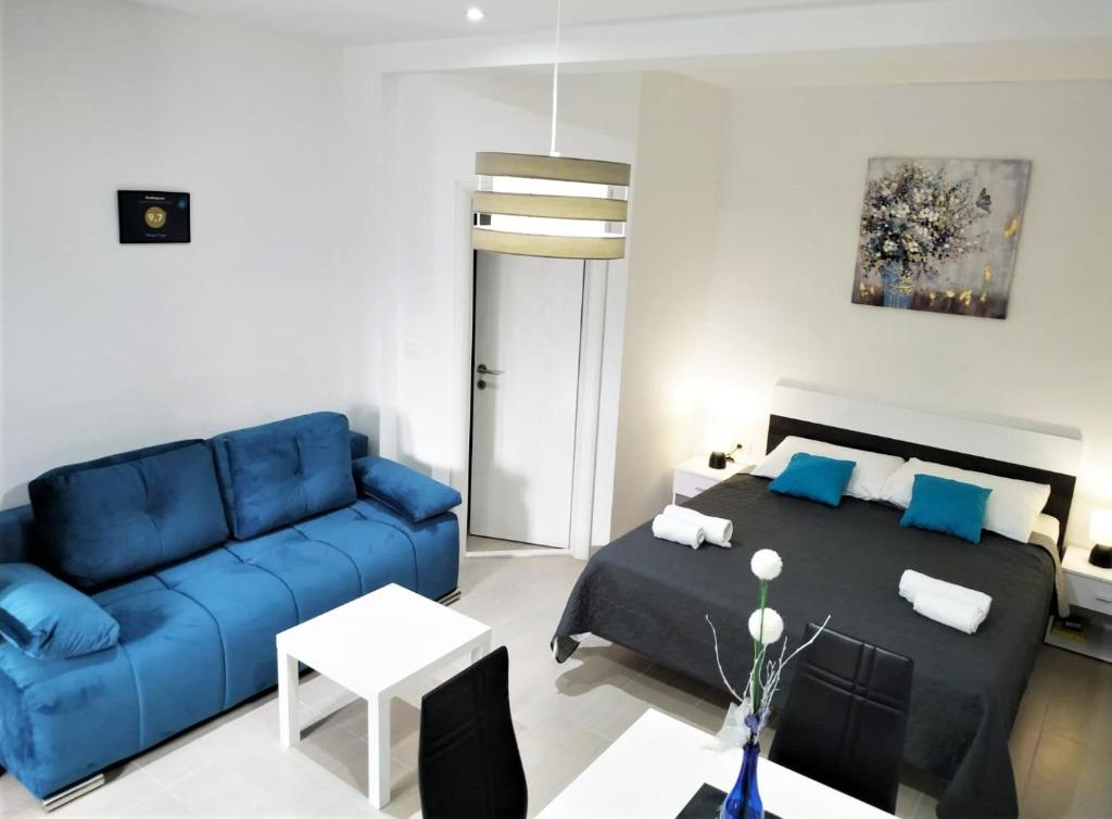 a living room with a blue couch and a bed at SeaEye Trogir in Trogir