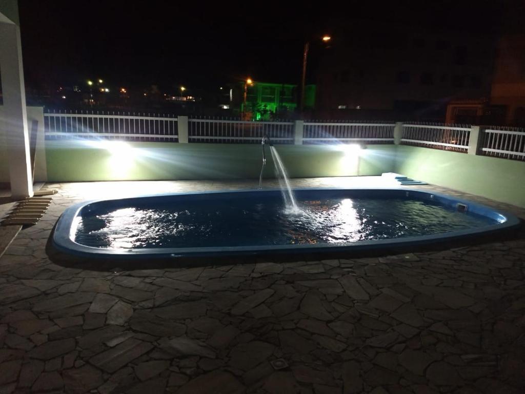 una fuente de agua en un patio por la noche en AP IVONETE -Victoria Residense, en Governador Celso Ramos