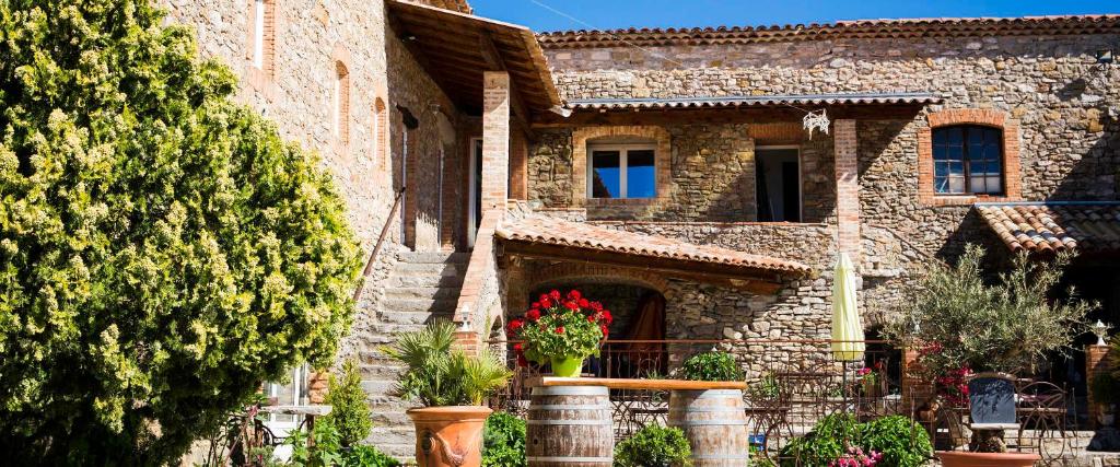 une maison en pierre avec un pot de fleurs devant elle dans l'établissement Les Chalets en Cévennes, à Saint-Christol-lès-Alès