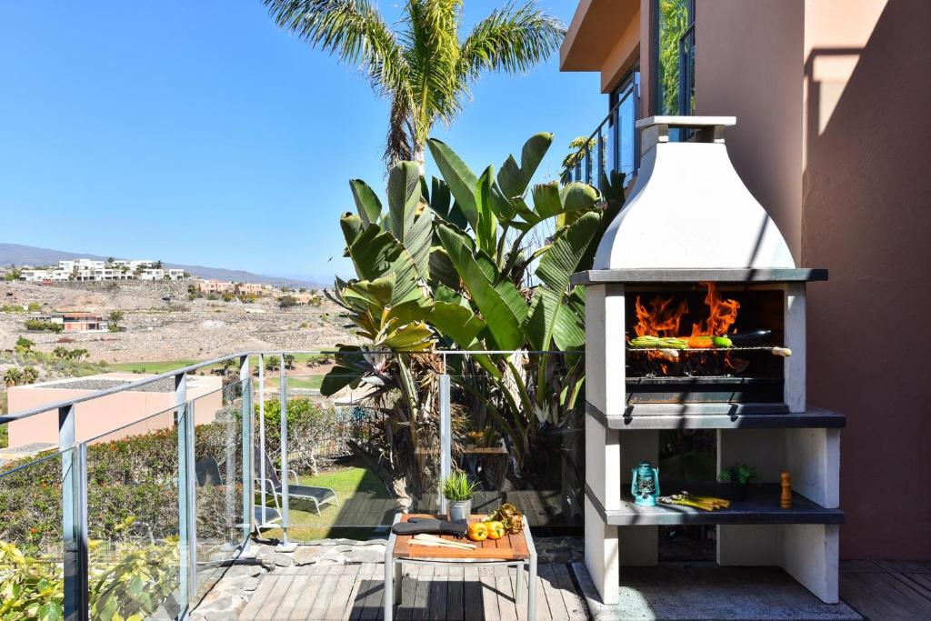 a fireplace on the side of a house with a balcony at GreenSide 38 by VillaGranCanaria in San Bartolomé de Tirajana