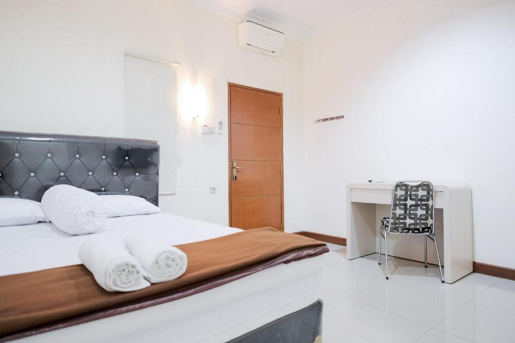 Postel nebo postele na pokoji v ubytování wisma delapan Mitra RedDoorz