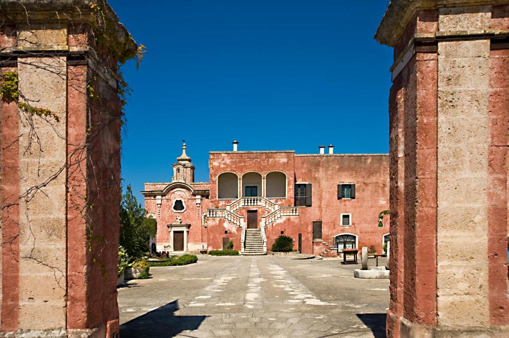 wejście do dużego budynku z czerwonej cegły w obiekcie Masseria Spina Resort w mieście Monopoli