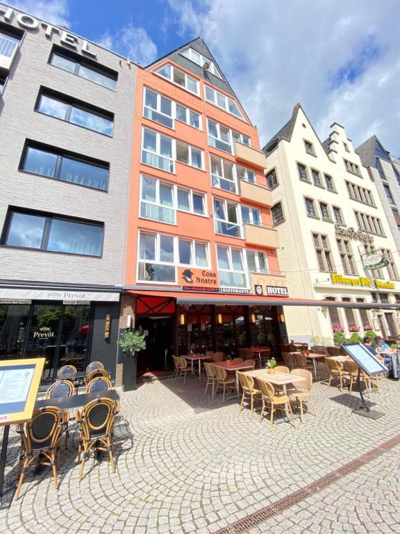 un groupe de tables et de chaises devant un bâtiment dans l'établissement Hotel Drei Kronen, à Cologne