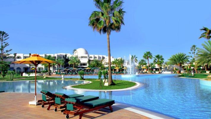 Djerba Plaza Thalasso & Spa في ميدون: مسبح وكراسي نخلة ونافورة