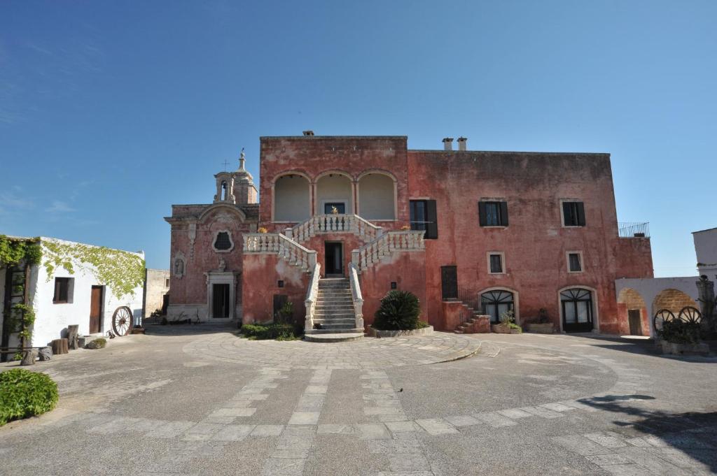 a large brick building with a staircase in front of it at Masseria Spina Resort in Monopoli