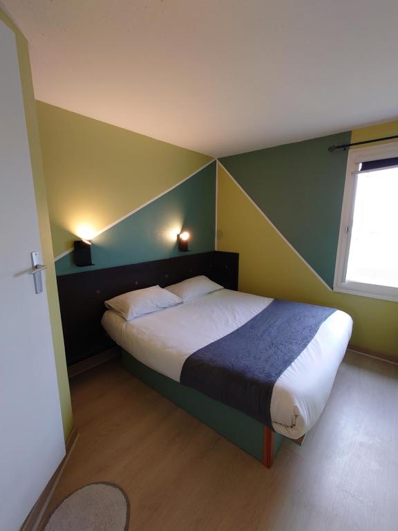 a bedroom with a bed with a green and yellow wall at Fasthotel Angers Beaucouzé in Beaucouzé