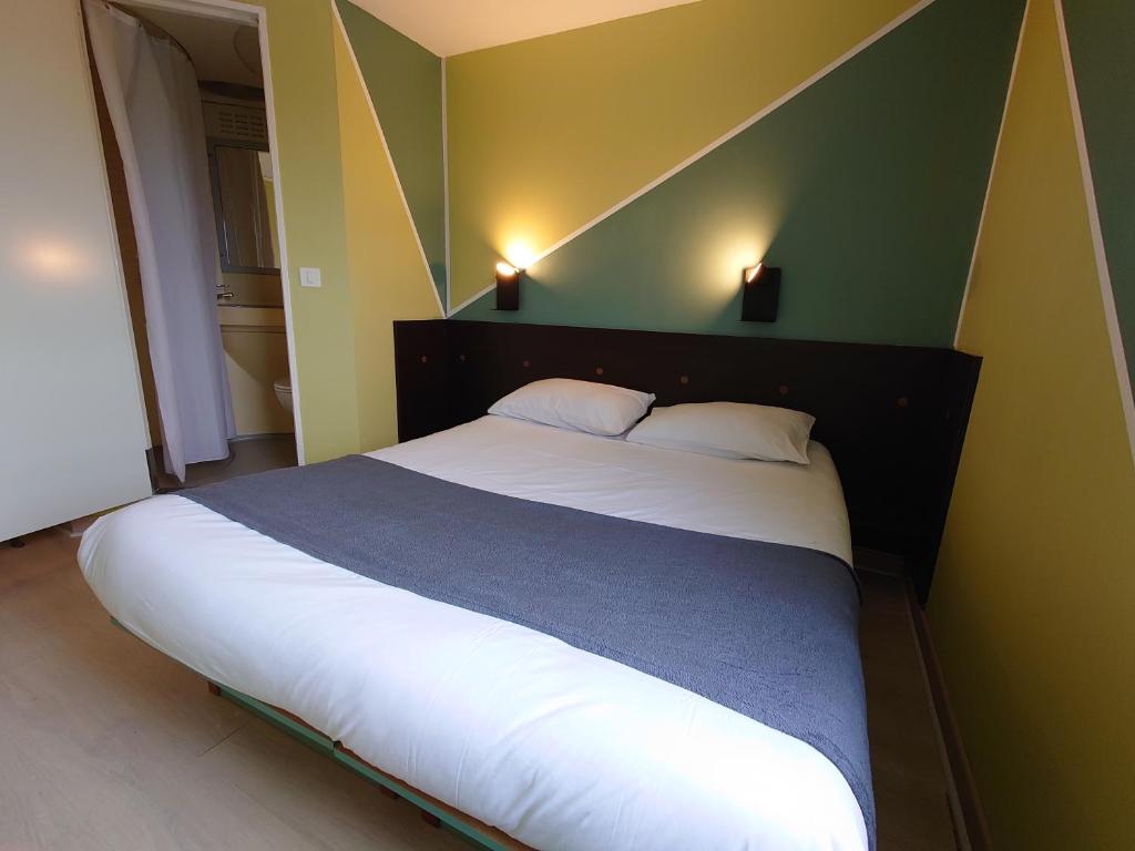 a bedroom with a large bed with white sheets at Fasthotel Angers Beaucouzé in Beaucouzé