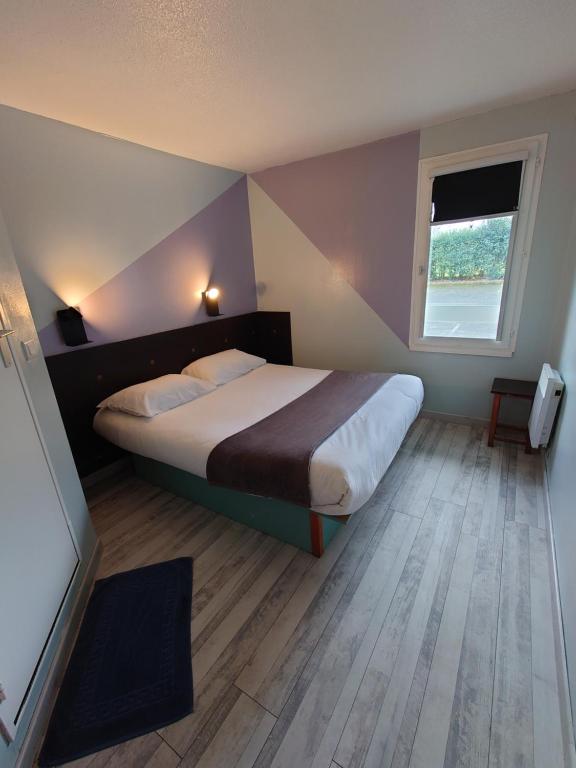 - une chambre avec un grand lit et une fenêtre dans l'établissement Fasthotel Angers Beaucouzé, à Beaucouzé