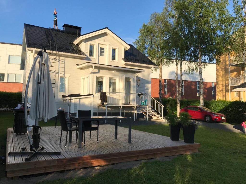 a house with a deck with a table and an umbrella at Moderni talo Tornion keskustassa in Tornio