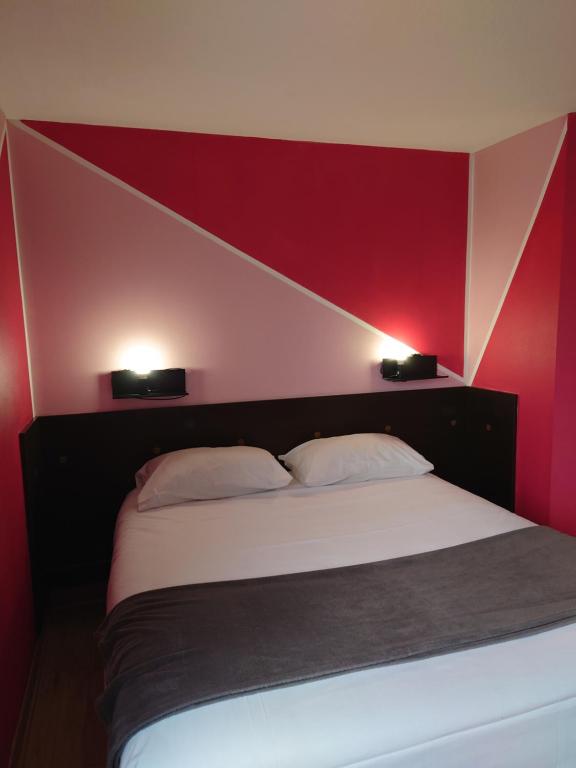 a bedroom with a red and white bed with two pillows at Fasthotel Angers Beaucouzé in Beaucouzé