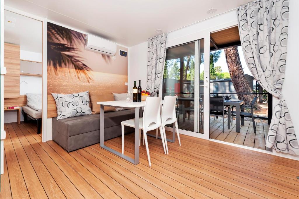 a dining room and living room with a table and chairs at FantaSea Mobile Home Porton Biondi in Rovinj