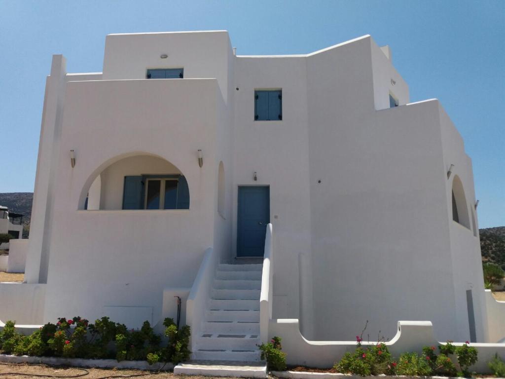 a white house with stairs in front of it at Agiassos Naxos Apartments in Agiassos